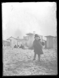 fo040054: Kind, in wintermantel, op het strand