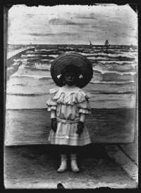 fo040204: Kind poseert bij een schildering van de zee