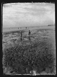 fo040206: Twee jonge kinderen, met emmertjes in de hand, op het strand
