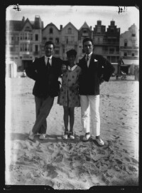 fo040120: Twee mannen en een jonge vrouw poseren samen op het strand