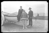 fo040121: Drie mannen poseren bij een bootje op het strand