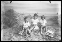 fo040057: Drie kinderen met speelgoed in een fotostudio 'aan zee'