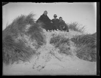 fo040123: Twee mannen en een vrouw poseren in de duinen