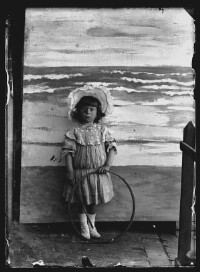 fo040200: Kind poseert bij een schildering van zee