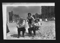 fo040079: Vrouw en twee mannen, in strandstoel, op het strand