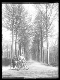 fo040283: Pose van 3 mannen op fiets langs een weg met bomen
