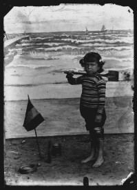 fo040078: Kind, met emmer en schopje, in een fotostudio 'aan zee'