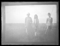 fo040174: Een vrouw en twee kinderen op een grasveld