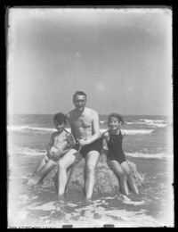 fo040010: Man en twee kinderen op een zandberg in zee