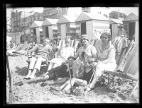 fo040012: Groepje mensen op het strand in strandstoel