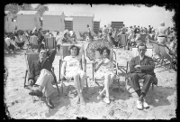 fo040184: Twee mannen en twee vrouwen in strandstoelen op het strand