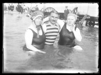 fo040086: Pose van 2 vrouwen en een man op het strand