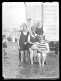 fo040085: Twee mannen en twee vrouwen poseren bij een strandcabine