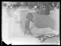 fo040155: Pose van een liggende vrouw aan strand