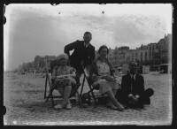 fo040090: Twee vrouwen, in strandstoel, en twee mannen op het strand
