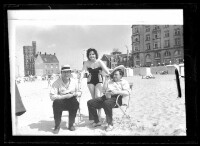 fo040105: Twee mannen, in strandstoel, en een vrouw op het strand