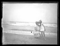 fo040022: Kind geeft vrouw een kus op de wang op het strand